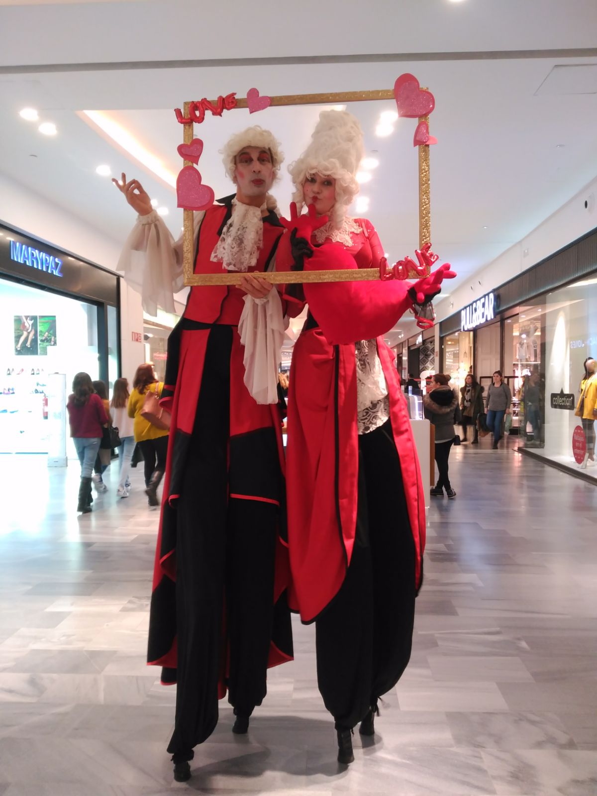 Fotocall con zancudos caracterizados de barroco en un centro comercial