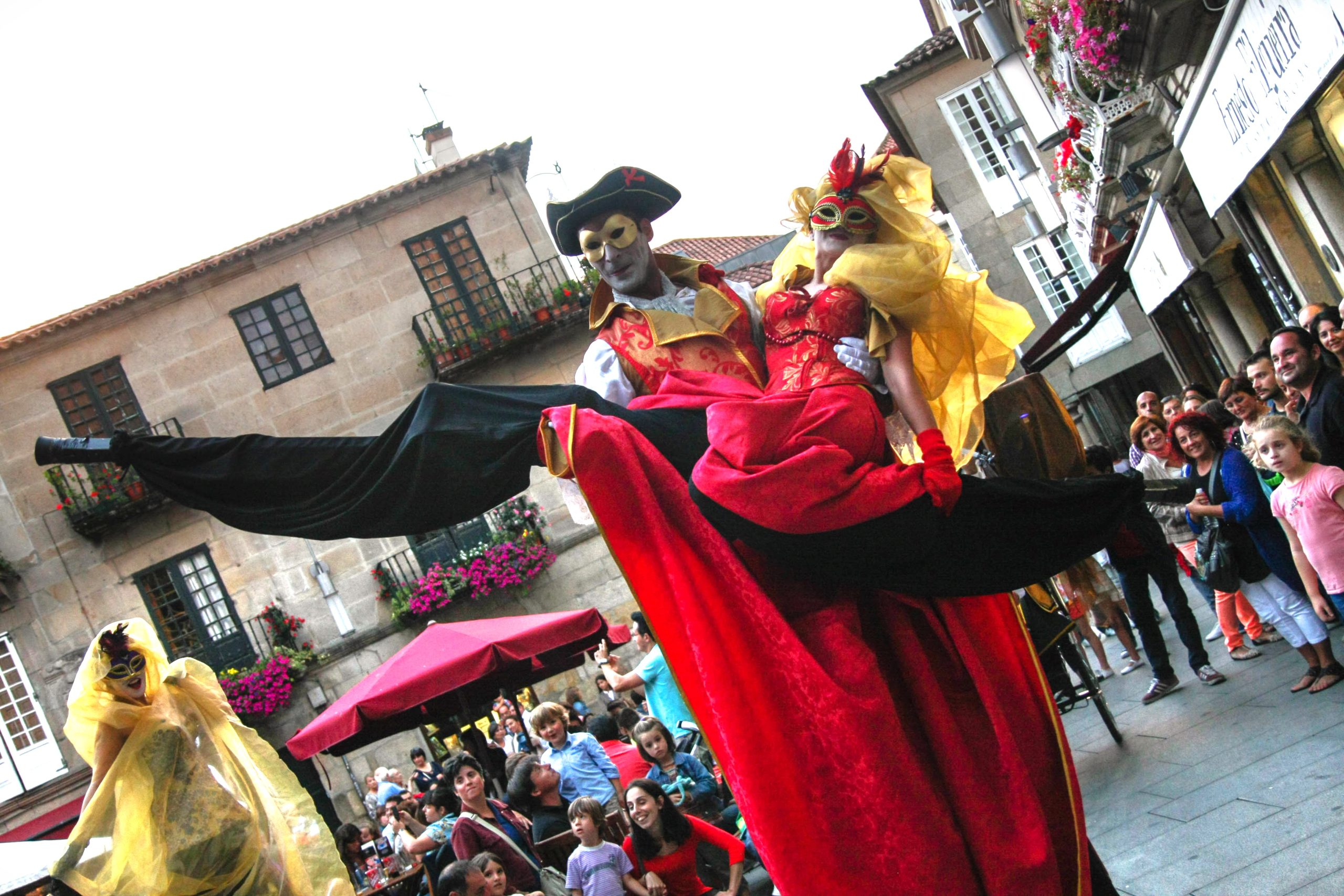 Un zancudo con máscara y sombrero de época eleva a su compañera, que luce un vibrante vestido rojo.