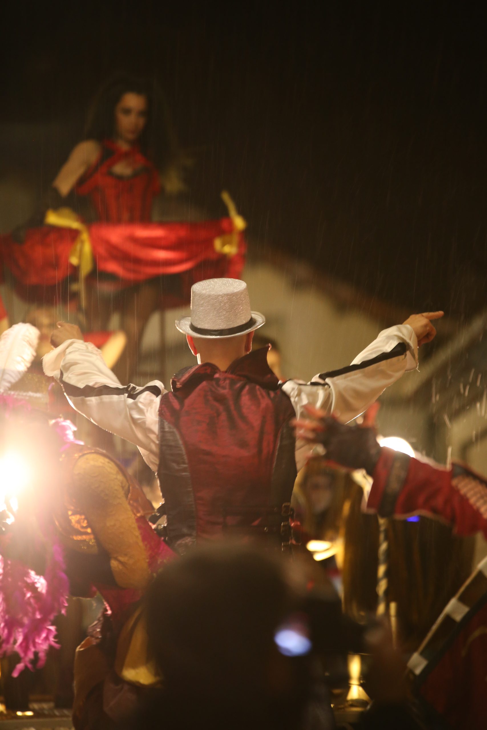Artista con sombrero de copa dirigiendo un show nocturno