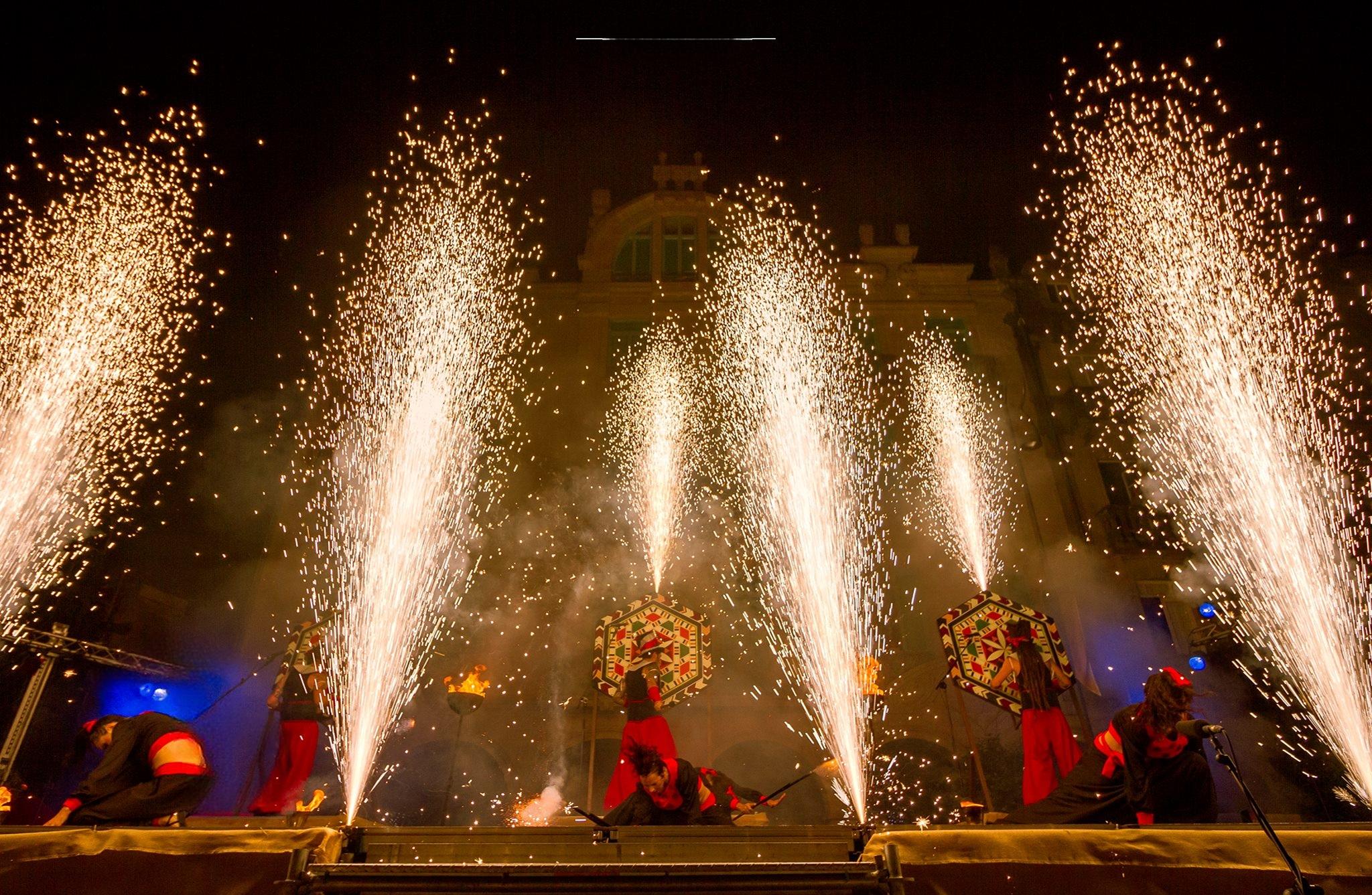 Espectáculo nocturno con fuego, chispas y artistas en escena